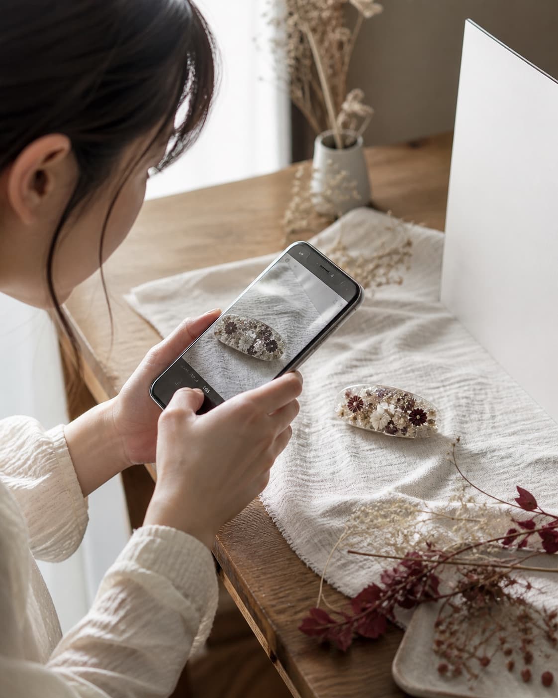 スマートフォンでハンドメイド作品を撮影する作家